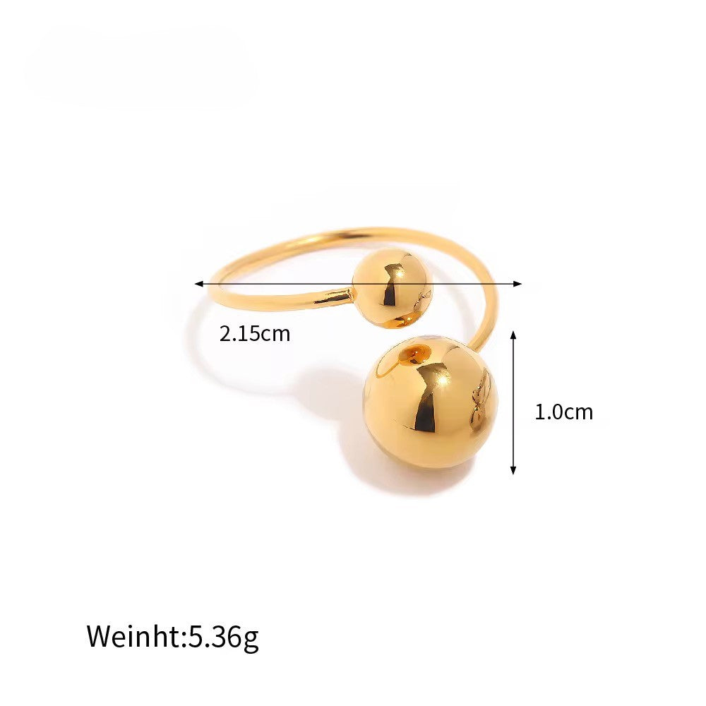 Gold ring with two spherical ends and measurements on a white background