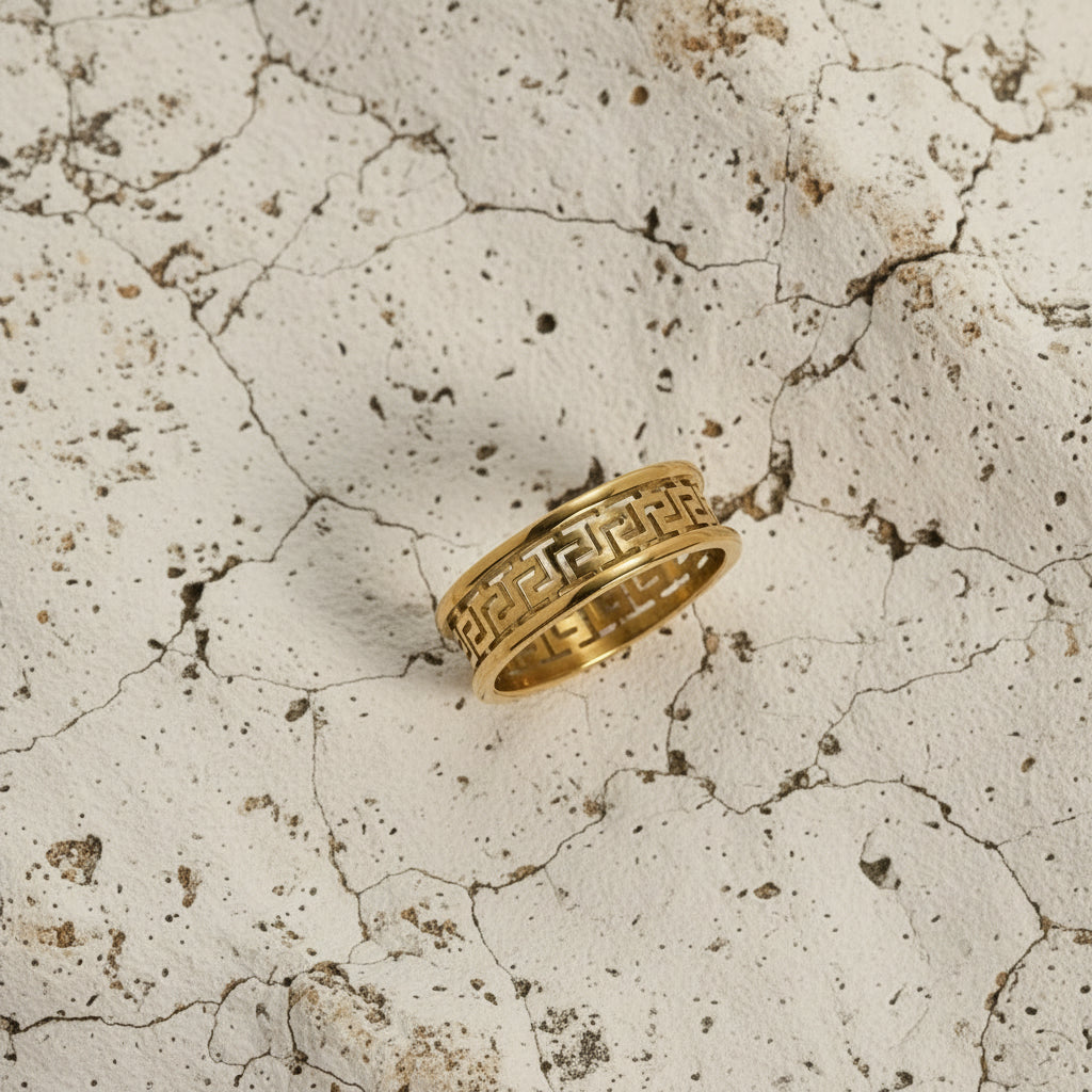 Goldring mit einem Muster auf einer beigen Steinoberfläche