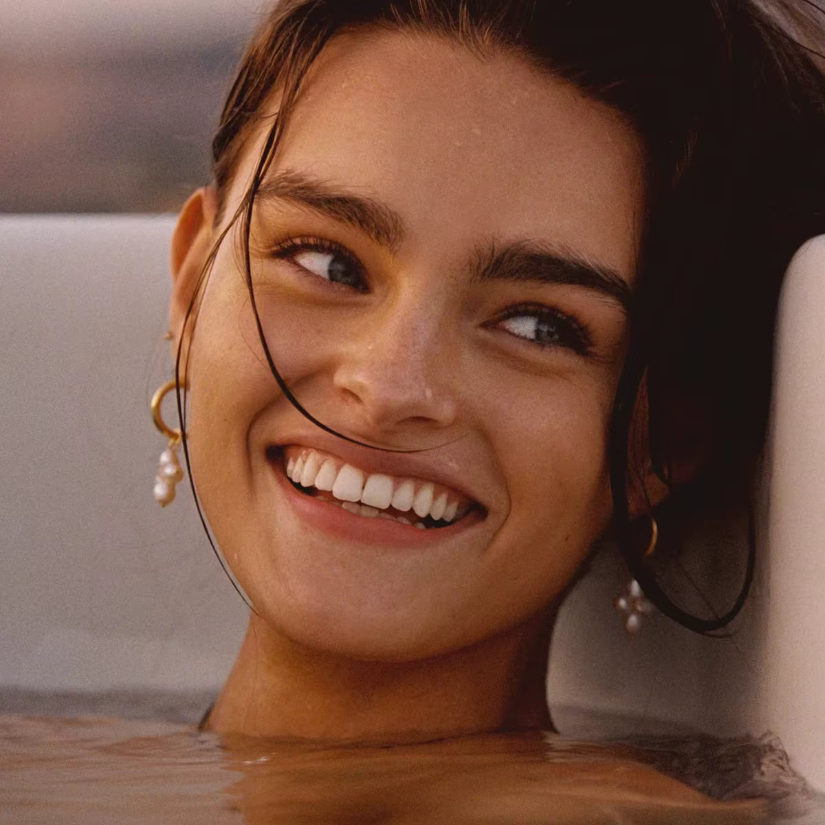 Woman with a radiant smile in a warm-toned setting