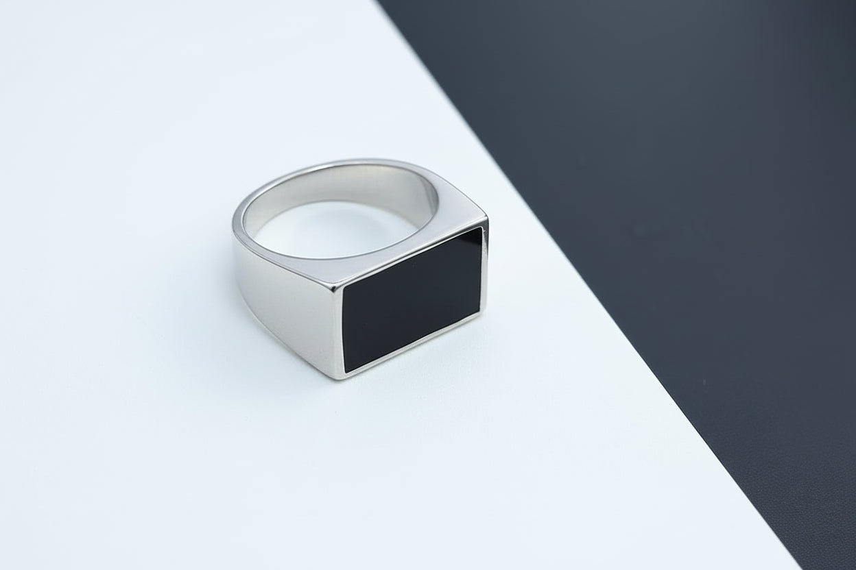 Silver ring with a black center on a white and gray background