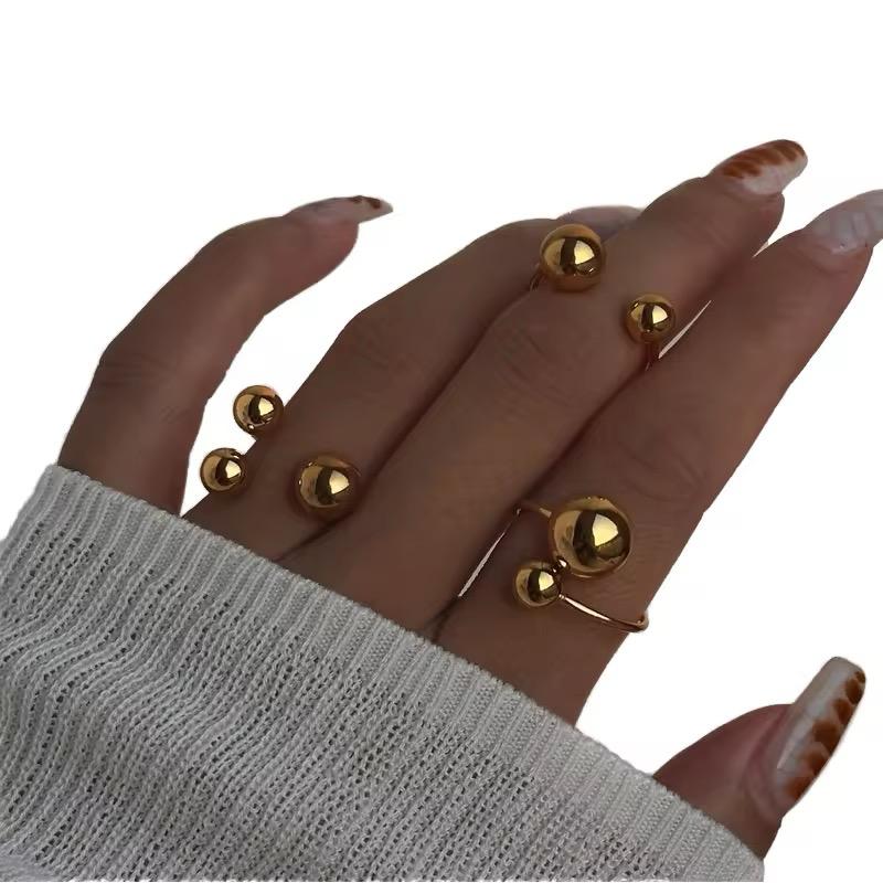 Hand mit mehreren Goldringen auf weißem Hintergrund