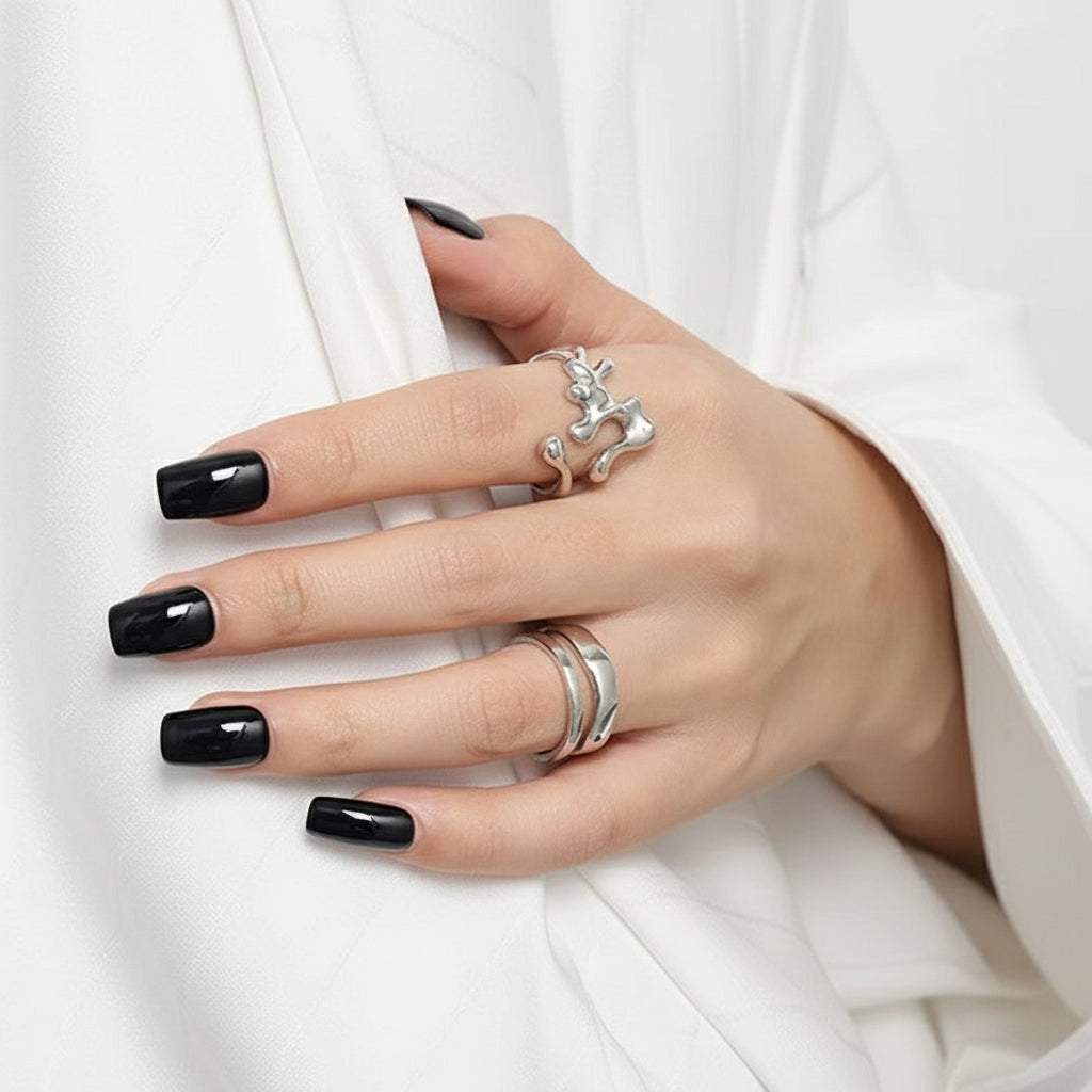 Ein rhodinierter Ring aus Sterlingsilber mit einem einzigartigen Design, möglicherweise interpretativ oder abstrakt, auf weißem Hintergrund.