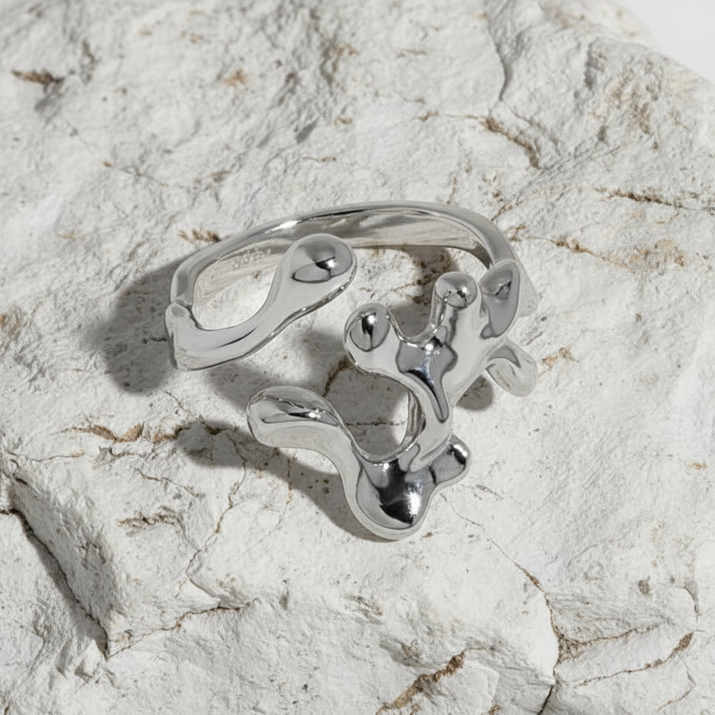 Ein rhodinierter Ring aus Sterlingsilber mit einem einzigartigen Design, möglicherweise interpretativ oder abstrakt, auf weißem Hintergrund.