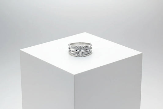 Silver ring on a wooden surface with a dark background