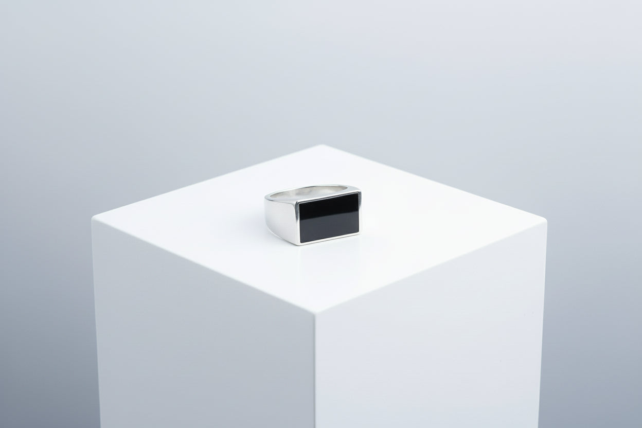 silver ring on a white pedestal against a light gray background