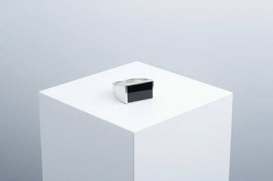 silver ring on a white pedestal against a light gray background