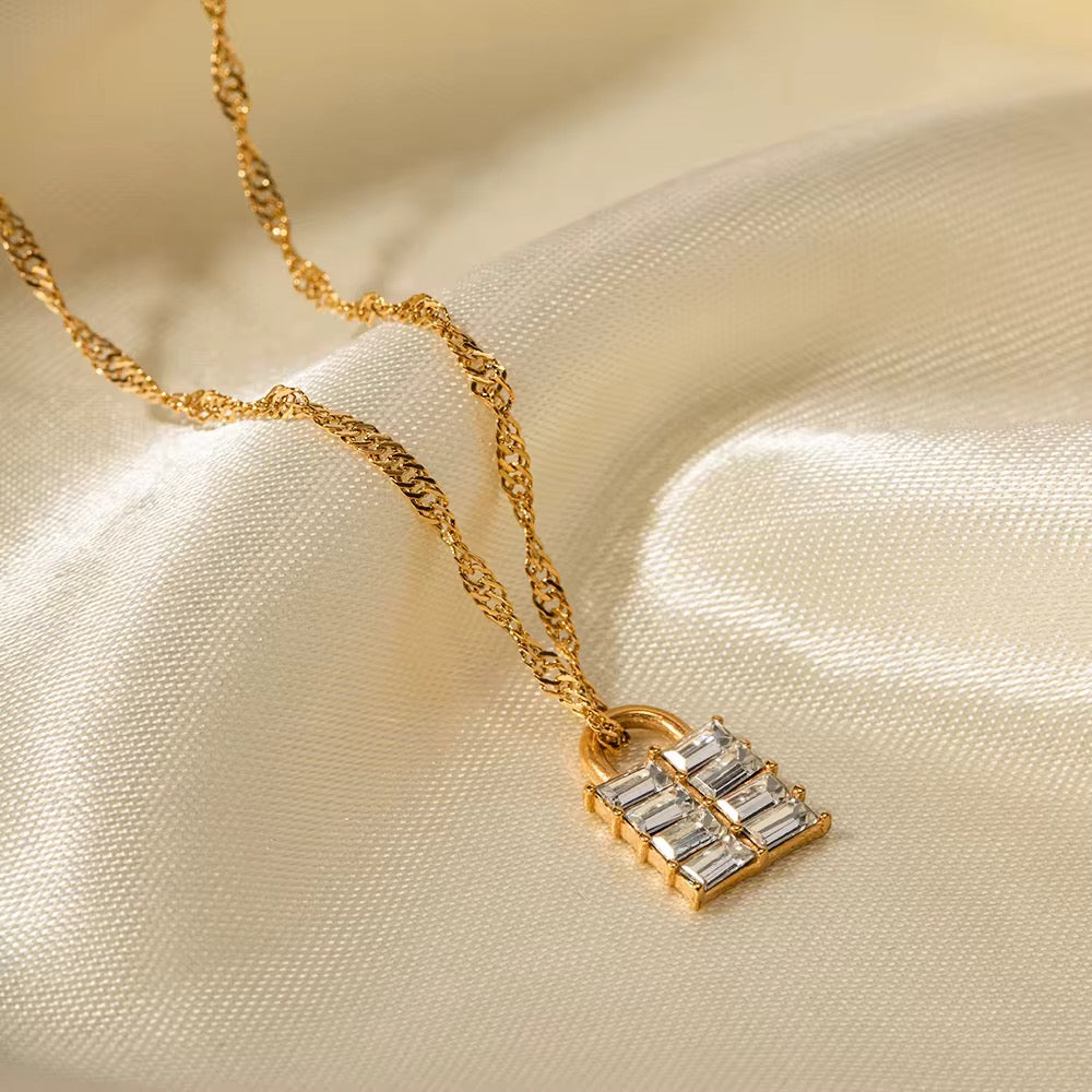 Nahaufnahme des Halses einer Frau, die eine vergoldete Edelstahlkette mit einem Anhänger aus weißem natürlichem Zirkon trägt.