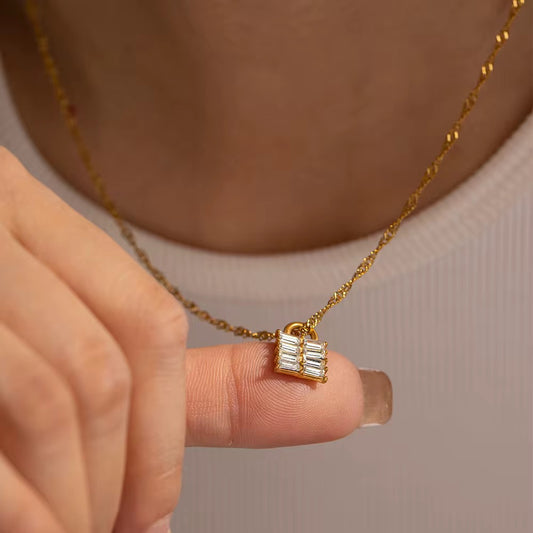 Nahaufnahme des Halses einer Frau, die eine vergoldete Edelstahlkette mit einem Anhänger aus weißem natürlichem Zirkon trägt.