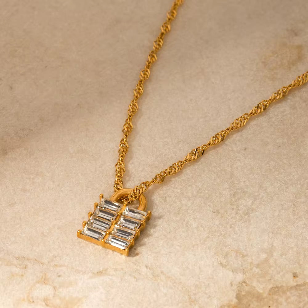 Nahaufnahme des Halses einer Frau, die eine vergoldete Edelstahlkette mit einem Anhänger aus weißem natürlichem Zirkon trägt.