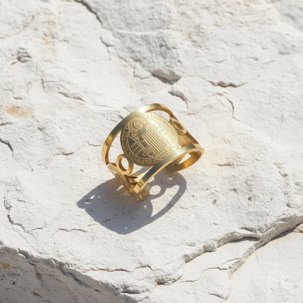 Ein Ring aus 18 Karat vergoldetem Edelstahl mit verstellbarem Band, präsentiert auf einem rosa Hintergrund mit einer Blume.