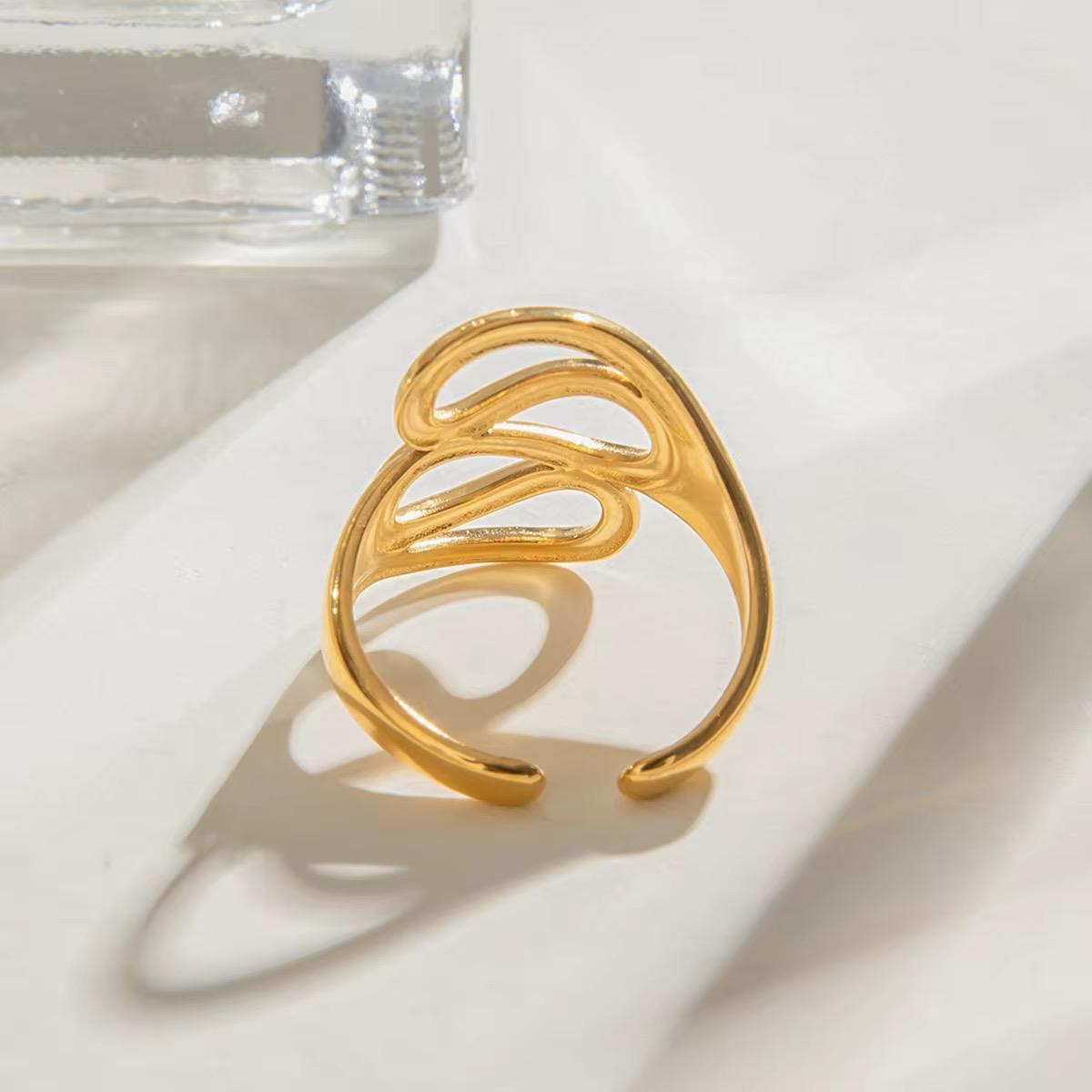 Goldring mit einem blattähnlichen Design auf weißem Untergrund