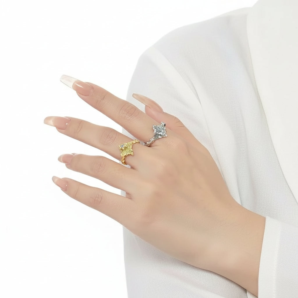 Ein vergoldeter Silberring mit Tropfenmuster und Zirkonsteinverzierung, dargestellt vor weißem Hintergrund.