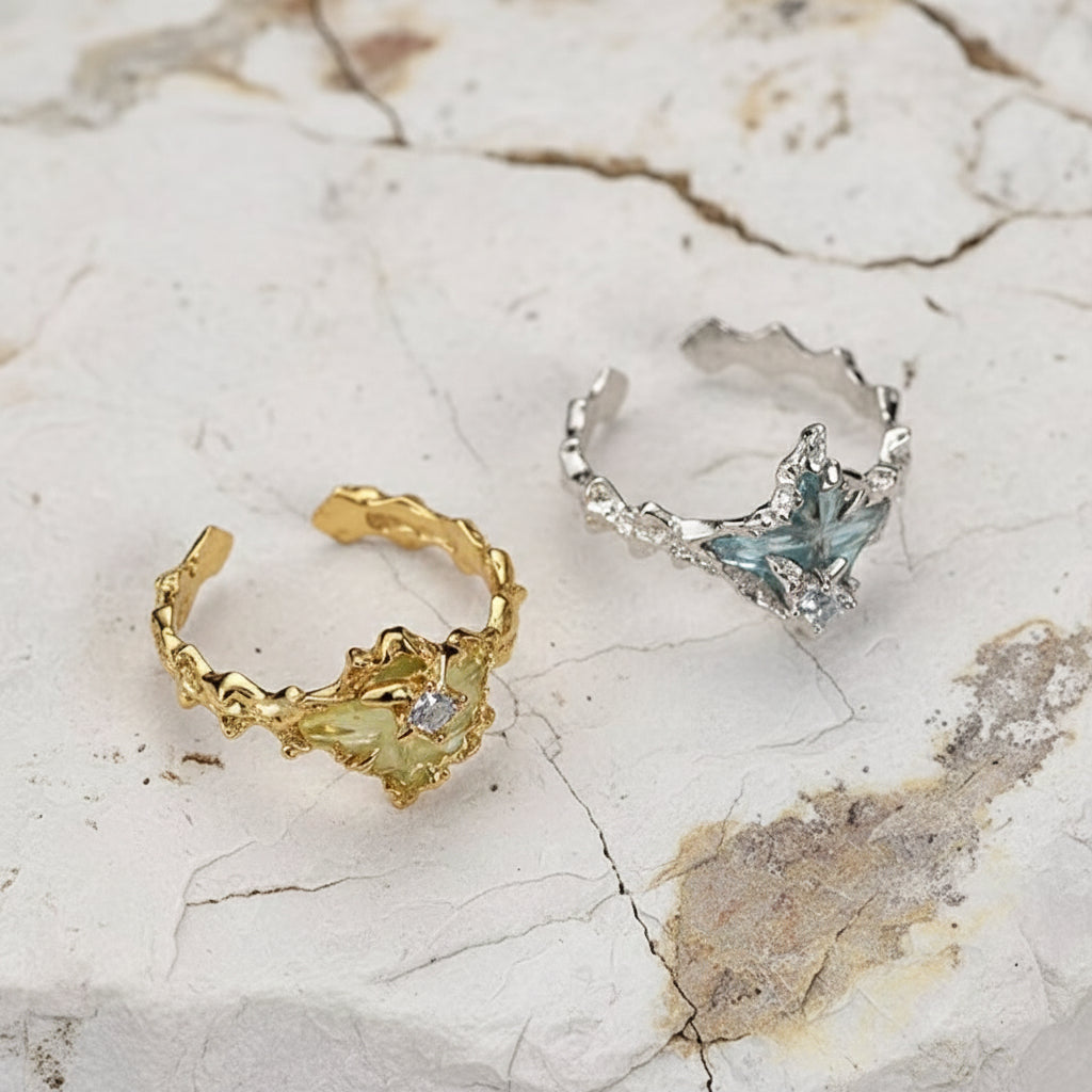 Gold- und Silber-Creolen mit Edelsteinen auf Marmorhintergrund