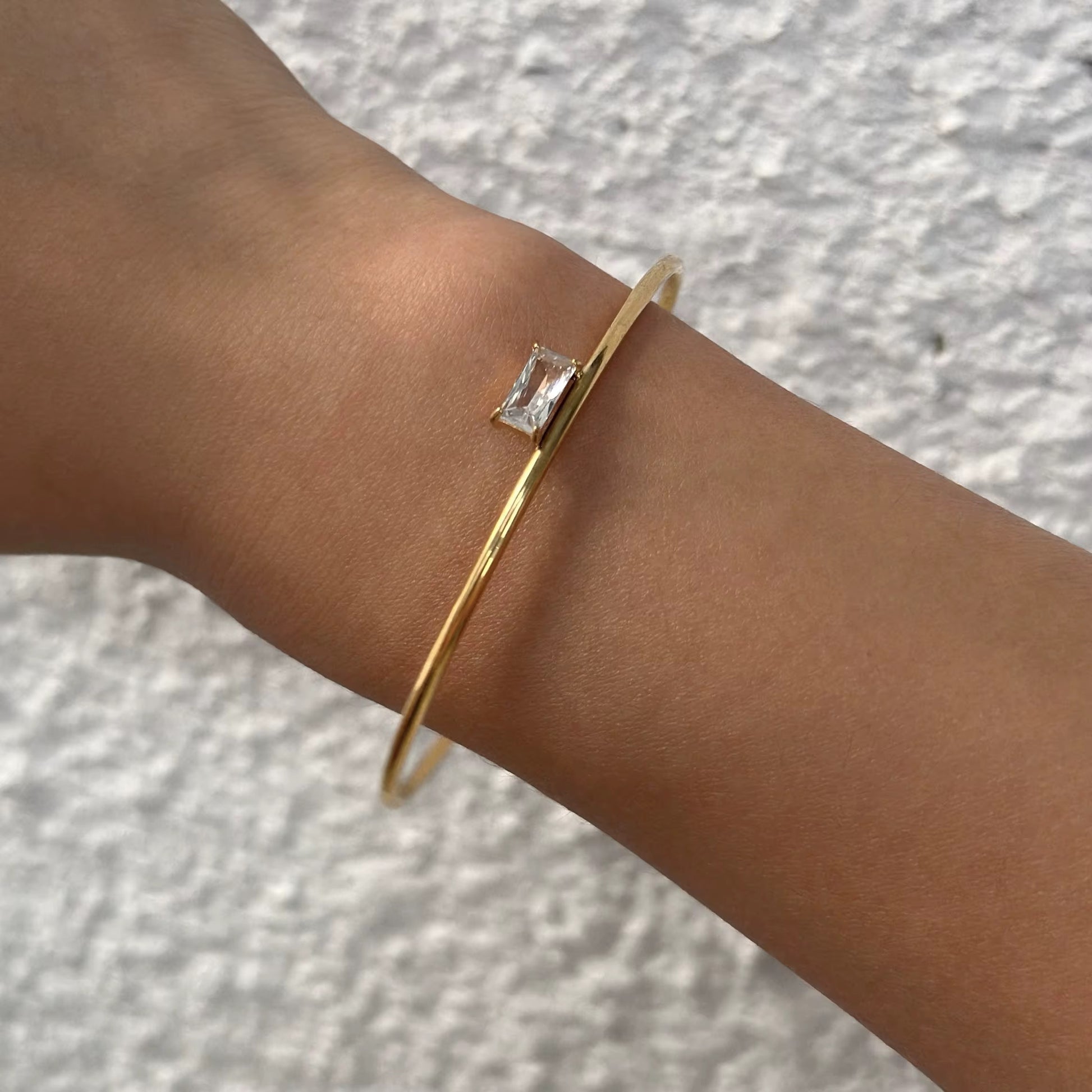 Vergoldetes Armband, das von einer Frau getragen wird.