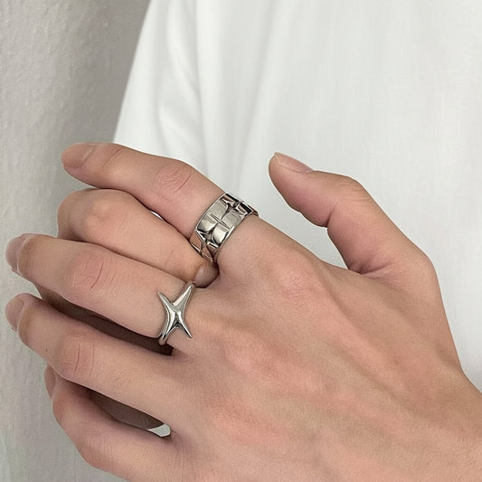 Hand mit zwei silbernen Ringen vor einem einfarbigen Hintergrund