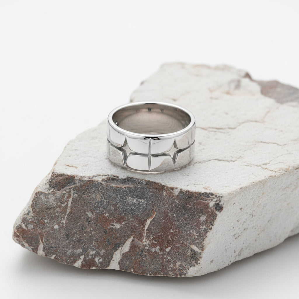 Silberring mit Sternmotiven auf weißem Hintergrund