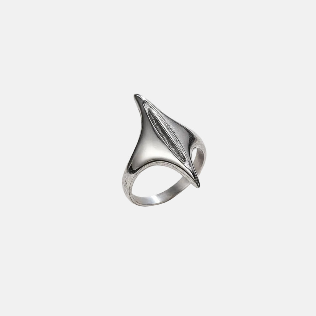 Ein versilberter Edelstahlring mit geometrischem Design, präsentiert auf einer strukturierten grauen Oberfläche.