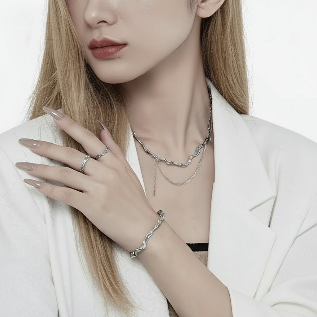 Frau mit Silberschmuck, darunter eine Halskette, ein Ring und ein Armband, vor weißem Hintergrund