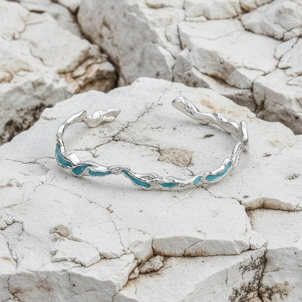 Ein verstellbares Armband aus Sterlingsilber mit mintblauen Akzenten, präsentiert vor einem weißen Hintergrund.